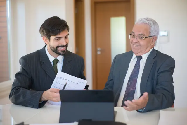 An adviser and a client smiling across a desk